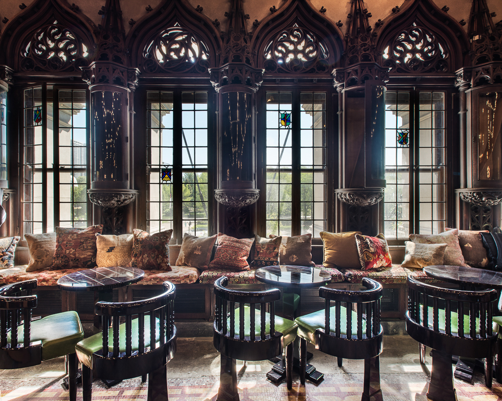 Historic lounge at Chicago Athletic Association featuring Gothic tracery, stained-glass accents, dark wood paneling, and restored architectural details.