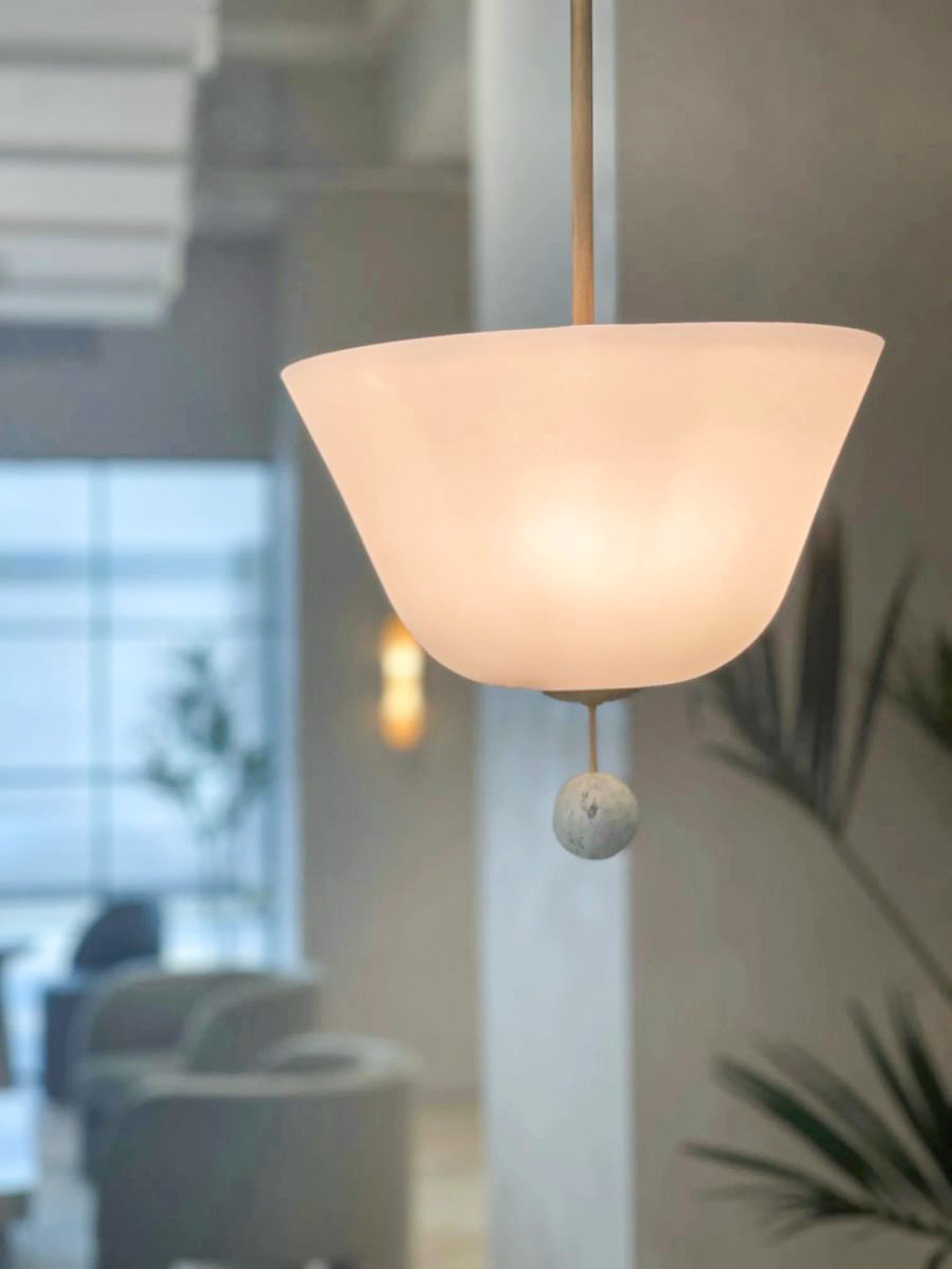 Pendant light featuring a carved Ming Green marble finial inside Bond Collective's restored Desmond Building workspace.