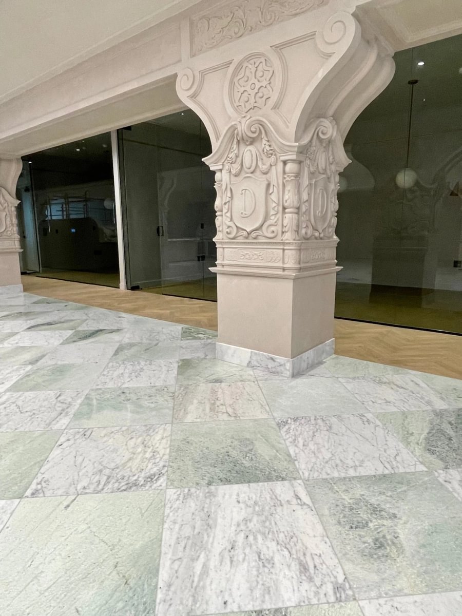 Ornamental wrought-iron railing and marble staircase preserved within Bond Collective's adaptive reuse of the historic Desmond Building in Downtown Los Angeles.