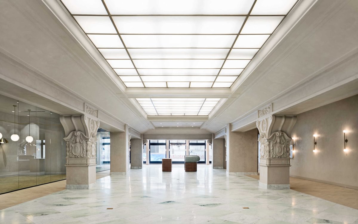 Historic lobby and event space at Bond Collective Los Angeles featuring Carrara and Ming Green marble checkerboard flooring within the restored Desmond Building.
