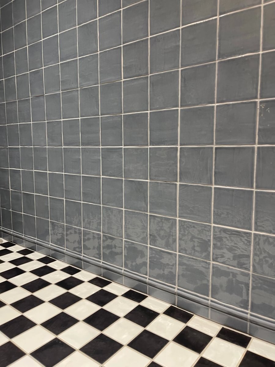 Bond Collective restroom featuring glossy blue-gray Cev Provencial ceramic wall tile and black-and-white checkerboard flooring at Bond Collective Los Angeles.